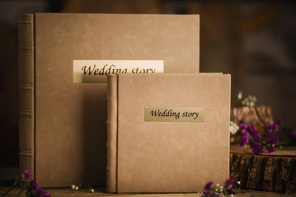 Photo book for wedding album on wood background. Wedding photo book, family album. Photo books with embossing and a cover of genuine leather. A book in an expensive binding.