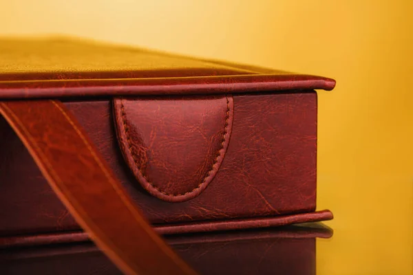Brown leather box on yellow background. stylish square cardboard box for a photo album. Bright original box for wedding album. Brown leather bag. Empty leatherette document box, used for storing paper