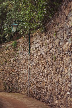 Meşhur Portofino 'nun dar sokakları. İtalya 'nın tarihi bir kasabasında, çiçek açan salkımlarla süslenmiş dar bir sokak. İtalyan Ortaçağ şehrinin romantik caddesi. 