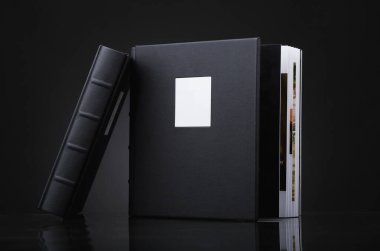 Siyah arkaplana karşı ciltli güzel bir deri kitap. Düğün fotoğrafları, aile albümleri. Siyah arka plan üzerine şık kitaplar. Gerçek deriden yapılmış bir fotobook 'un kapağının dokusu..