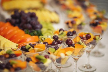 Büfe resepsiyonu meyveleri, şaraplar, şampanya. Düğün masasında meyve tabağı. Yemek kanapesi çeşitli taze meyveler, böğürtlenler ve narenciye. Tatil için meyveler. Etkinlikte restoran servisi.