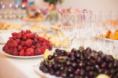 Büfe resepsiyonu meyveleri, şaraplar, şampanya. Düğün masasında meyve tabağı. Yemek kanapesi çeşitli taze meyveler, böğürtlenler ve narenciye. Tatil için meyveler. Etkinlikte restoran servisi.