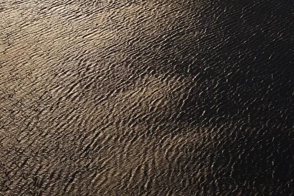 Water texture. Water Surface of a River on a Sunset with Reflections. surface of the ocean with gentle ripples on the surface and light refracting. water, lake, wave, background. Natural Water Texture