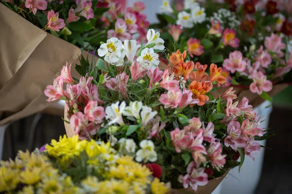 Colorful alstroemerias on the stand in the flower shop. Showcase. Floral shop and delivery concept. Flowers market on the street. Many alstroemeria flowers growing in pots for sale in florist\'s shop.