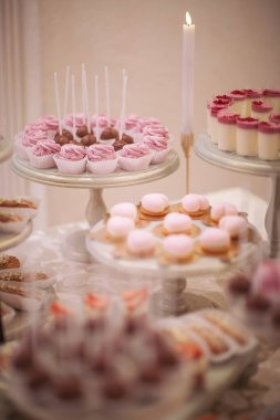Kokteyl partisi ya da mağaza raflarında servis edilen pek çok küçük kek, şeker, meyve. Doğum günü veya düğün yemeği için çikolata. Yemek servisi. Lezzetli bir tatlı. Düğün yemeği masası.