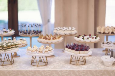 Çeşitli lezzetli tatlılar, kremalı kekler, böğürtlen, krem şanti, lokum, şenlikli dekor, tatlı bar, ikram. Yemek servisi. Lezzetli bir tatlı. Düğün ziyafeti masası. Tatlı büfede hamur işi