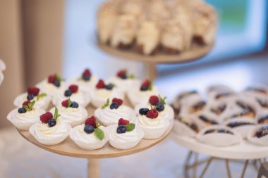 Çeşitli lezzetli tatlılar, kremalı kekler, böğürtlen, krem şanti, lokum, şenlikli dekor, tatlı bar, ikram. Yemek servisi. Lezzetli bir tatlı. Düğün ziyafeti masası. Tatlı büfede hamur işi