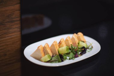 Somon, beyaz bir tabakta. Yakın plan. Düğün yemeği masasını kutluyoruz. Ziyafet masası. Masa takımı. Yiyecek, atıştırmalık, balık, zeytin, sebze. Otelde açık büfe kahvaltı. Restoran.