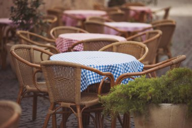 Kafe kafe restoranının terasında. Tahta sandalyeler ve masalar. Açık teras konsepti. Sığ odaklanma. Uzayı kopyala Antika sandalyeleri ve masaları olan eski moda boş kafe terası. Çatı katı tarzı kafe.