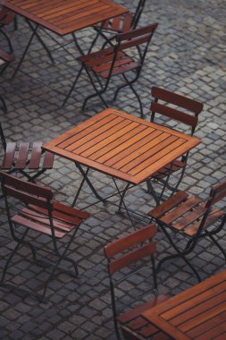 Tahta sandalyeler ve masalar. Açık teras konsepti. Uzayı kopyala Antika sandalyeleri ve masaları olan eski moda boş kafe terası. Çatı katı tarzı kafe. Boş restoran yaz terası. Sokak görünümü