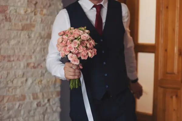 Elegance wedding decorations. Wedding bouquet for the bride and groom at an event. A stylish groom with a beautiful bouquet in his hands. Wonderful luxury wedding bouquet of different flowers.