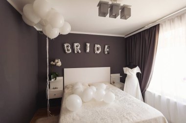 Güzel dekore edilmiş balonlarla dolu bir gelin odası. Parlak balonlardan bir gelin. Gelinin yatak odasında şık beyaz gelinlik