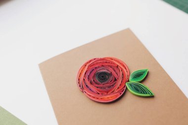 Beyaz kağıt üzerinde gül çiçeği olan tüy kalem kartı. Kağıt kalem tekniğindeki tebrik kartlarından yapılmış bir el. Evde el işi. Hobi, ev ofisi. metin için boşluk kopyala.