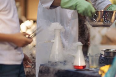 Kimyasal reaksiyon yakın çekim. Sıvı nitrojen reaksiyonu sonucu dumanlı cam matara. Nitrojen bilimsel deneyler ve çocuklar için gösterim. Kuru buz ve dumanla yapılan kimyasal deneyler..