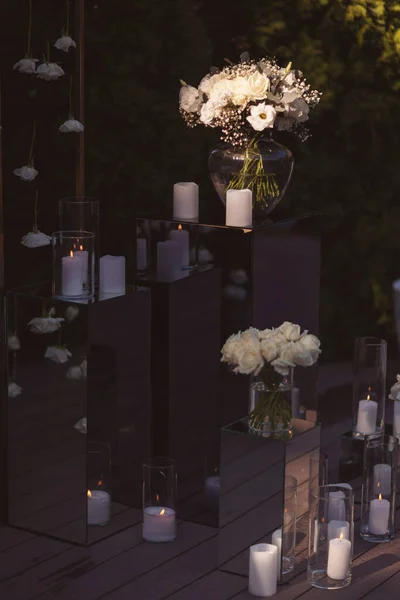 View of elegant expansive white flowers and candles in selective light, decoration for wedding party. the wedding ceremony in the open air. Luxury and beautiful wedding decor. Decor details