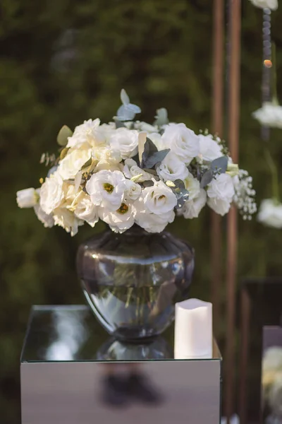 View of elegant expansive white flowers and candles decoration for wedding party. the wedding ceremony in the open air of fresh flowers, with candles. Luxury and beautiful wedding decor. Decor details.