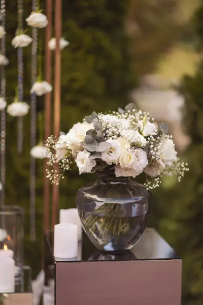 View of elegant expansive white flowers and candles decoration for wedding party. the wedding ceremony in the open air of fresh flowers, with candles. Luxury and beautiful wedding decor. Decor details