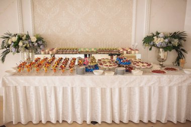 Farklı çeşit kekleri olan çikolatalar. Düğün şekeri büfesinde tatlı, tatlı ve kek. Tatlılar, farklı tatlılar küçük renkli tatlı kekler.