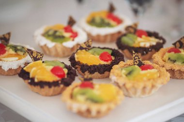 Farklı çeşit kekleri olan çikolatalar. Düğün şekeri büfesinde tatlı, tatlı ve kek. Tatlılar, farklı tatlılar küçük renkli tatlı kekler.