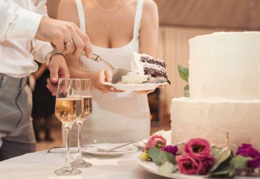 Düğün pastası. Gelin ve damat geçmişi bulanık düğün pastası. Düğün partisinde süslemeli düğün pastası. Beyaz, üç katlı, çiçeklerle süslenmiş..