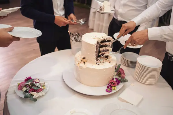 Waiters cut the wedding cake. Banquet. Piece of wedding cake. detail of luxury wedding Dessert. cutting cake with colouring sugar. Cut slice of celebrating cake.