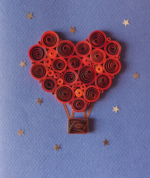 quilling card with heart balloon between the stars. Happy valentine day. Greeting cards. Hand made of paper quilling technique. Handicraft at home. Hobby, home office. Heart from red paper ribbons