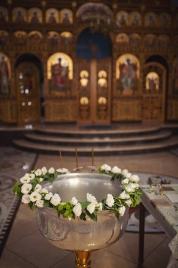 Tapınaktaki vaftiz töreninde bebekleri yıkamak için kullanılan çiçek süsüyle metal leğen (font). Manastırda vaftiz töreni. Hıristiyan kilisesinde vaftiz töreni..