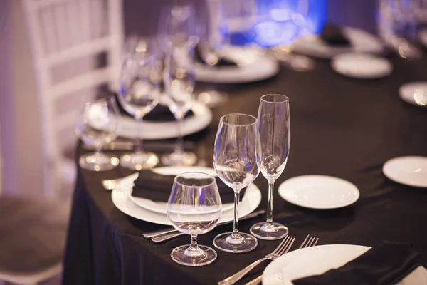 Luxury Table setting focus on the glass blue and purple background. Empty glasses set in restaurant.