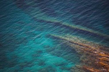 Deniz kenarında. Deniz kıyısının dokusu. Deniz manzarası, sahildeki kayalar turkuaz deniz suyu. Liguria, İtalya.