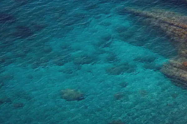Deniz kenarında. Deniz kıyısının dokusu. Deniz manzarası, sahildeki kayalar turkuaz deniz suyu. Liguria, İtalya.