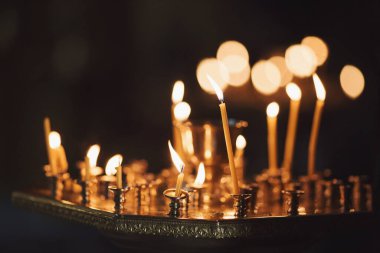 Sönmüş mumlardan duman çıkıyor. Kilisede mumları olan bir avize. Yumuşak odaklanma. Maviydi. Kilise mumları. Ortodoks kilisesinde şamdanda mum yakmak. Dini bir ritüel.