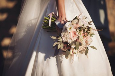 Gelinin elinde zarif bir düğün buketi. Gelinin ellerinde pembe gül buketi.. 