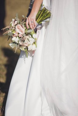Gelinin elinde zarif bir düğün buketi. Gelinin ellerinde pembe gül buketi.. 