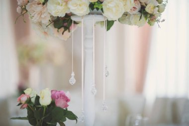 Düğün günü masada güzel çiçekler. Masa dekorunda çiçek masa numaraları ve mumlar var. Ayarlanmış masada bir demet çiçek.. 