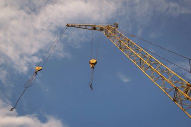 Mobil vinç parçası mavi gökyüzüne çarpıyor. Vinç patlaması ve yapısı, vinçin altından yer seviyesinden alınıyor. Endüstriyel vinç.