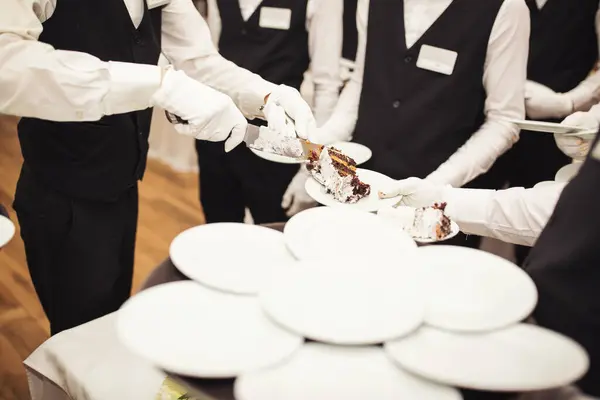 Waiters cut the wedding cake. Banquet. Piece of wedding cake. detail of luxury wedding Dessert. cutting cake with colouring sugar. Cut slice of celebrating cake.