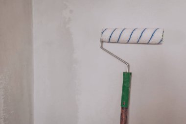 Boya yapmadan ya da duvar kağıdı yapıştırmadan önce astar macun duvarlı bir silindirle hazırlanmış. Daire tadilatı, ev tamiri, boya silindiri.. 