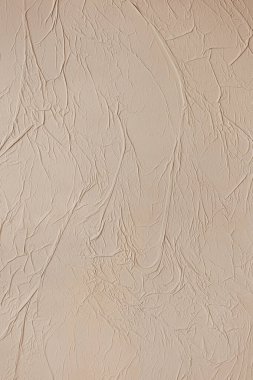 Soyut bir arkaplan olarak duvardaki dekoratif alçı. Bej bir duvarın dokusu. Duvardaki grunge dekoratif kağıt. 