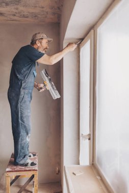 Alt duvar sıva ile genel giyen inşaat işçisi yenilenen daireli ev araçları. Sıvacı yenilenen kapalı duvar ve tavan float ve alçı ile. İnşaat bitirme işleri.
