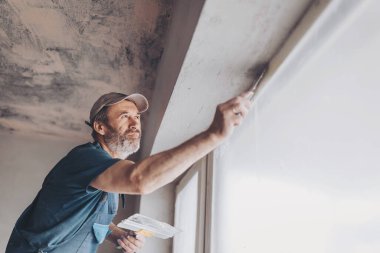 Alt duvar sıva ile genel giyen inşaat işçisi yenilenen daireli ev araçları. Sıvacı yenilenen kapalı duvar ve tavan float ve alçı ile. İnşaat bitirme işleri.