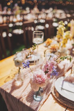 Aile yemeği ya da dışarıda toplanmak için güzel bir dekorasyon masası. Güneşli bir günde. Düğün töreni, özel parti. Gece için lamba asmak.