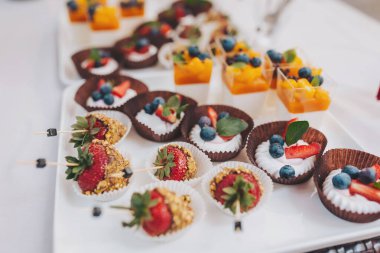 Çikolata. Lezzetli tatlı büfe. Tatlı bayram büfesi, kapkekler, çilekler ve meyveli ve meyveli diğer tatlılar. Şeker, şeker ve tatlı dolu bir masa..