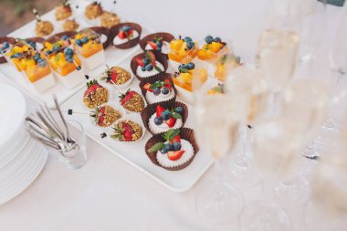 Çikolata. Lezzetli tatlı büfe. Tatlı bayram büfesi, kapkekler, çilekler ve meyveli ve meyveli diğer tatlılar. Şeker, şeker ve tatlı dolu bir masa..