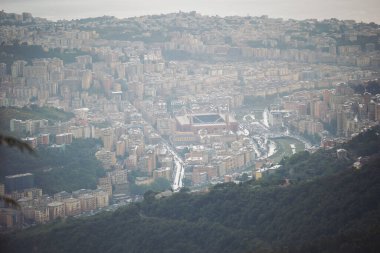 foggy Genova town, Italy, aerial view. Beautiful aerial view of Val Bisagno, Marassi district, Bisagno river and Stadio Luigi Ferraris football stadium, home of Genoa and Sampdoria football clubs clipart