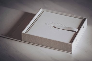 Beyaz deri kaplamalı düğün fotobook 'u. Düğün fotoğrafı defteri, albüm aile albümü. Kabartmalı fotoğraf kitapları ve hakiki deriden bir kapak. Bir tipografi ve tasarımcının hizmetleri. 