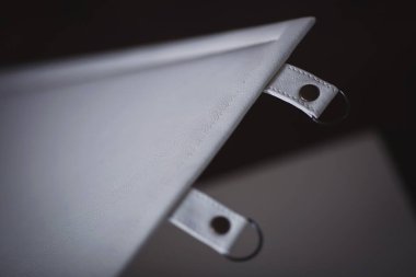 Deri kutunun içindeki beyaz düğün fotoğraflarının ayrıntıları. Fotoğraf kitapları için şık bir hediye kutusu. Bej renkli hediye kutusunda perçin ve saplı beyaz aile fotoğrafı. fotoğraf albümü deri kutuda. 