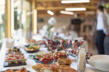 Düğünde soğuk, sıcak aperatiflerle birlikte ziyafet masası servis edildi. Abur cuburlarla dolu bir masa, düğün için yemek servisi. Kurumsal catering etkinliğinin büfe masasında çeşitli atıştırmalıklar ve içecekler.