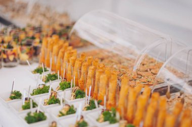 Düğün resepsiyonunda churro bar, etkinlikte churros, kapat. Masada çeşitli atıştırmalıklar, ziyafet yemekleri. Açık büfe masasında egzotik yemekler var. Kanepeleri ve farklı yemekleri olan lezzetli bir açık büfe. 