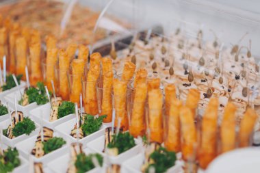 Düğün resepsiyonunda churro bar, etkinlikte churros, kapat. Masada çeşitli atıştırmalıklar, ziyafet yemekleri. Açık büfe masasında egzotik yemekler var. Kanepeleri ve farklı yemekleri olan lezzetli bir açık büfe. 