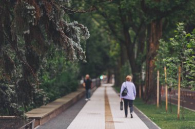 Sokakta yürüyen bulanık insanlar. Şehir parkındaki Bokeh arka planındaki soyut bulanık insanlar. Görüntü ve bokeh dokusu. Bir yaz gününde sokaklardaki insanlar....